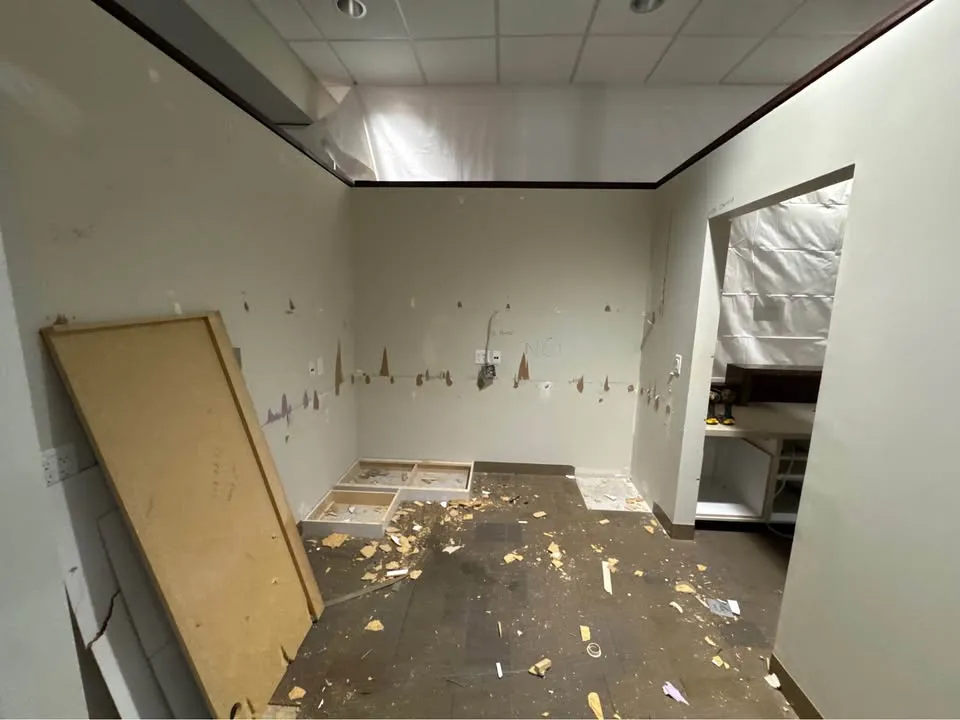 Office room stripped of fixtures, with a door leaning against the wall