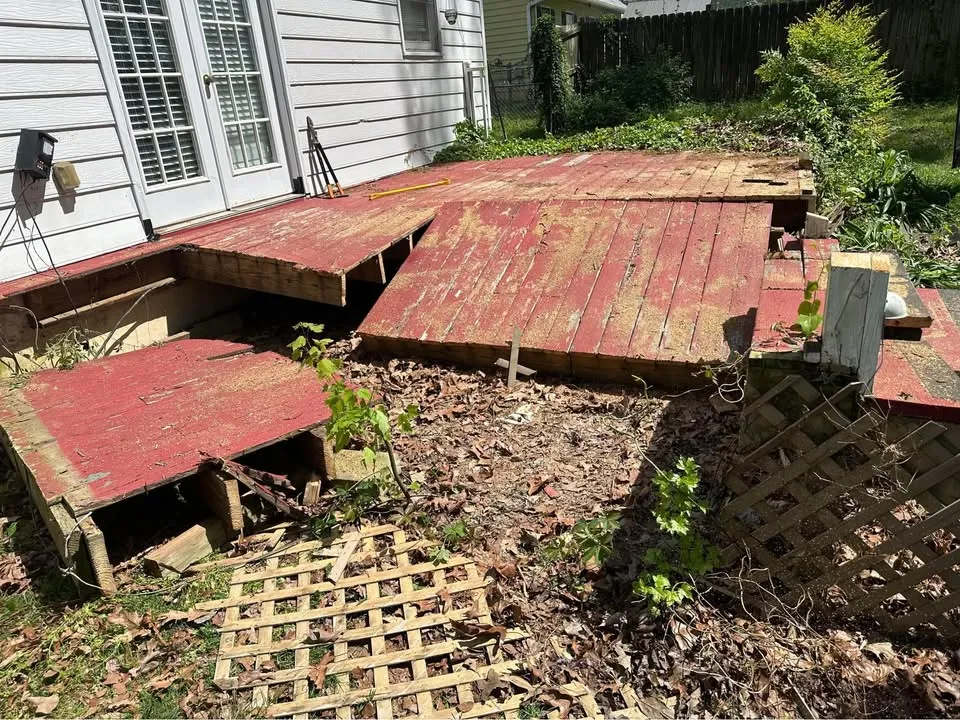 Deck boards and lattice being removed from a backyard deck