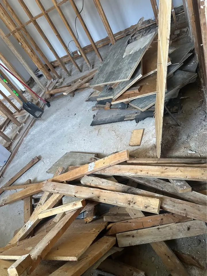 Removed lumber and flooring stacked in a gutted room