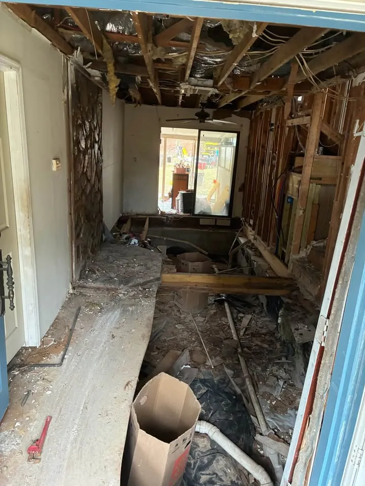 Narrow room gutted to the framing with the ceiling boards pulled down