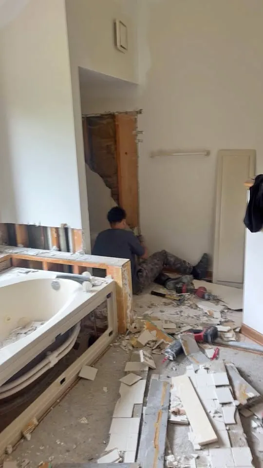 Bathroom tear-out in progress with the tub surround and tile removed