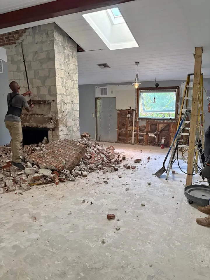 Stone fireplace surround broken out, with brick rubble on the floor