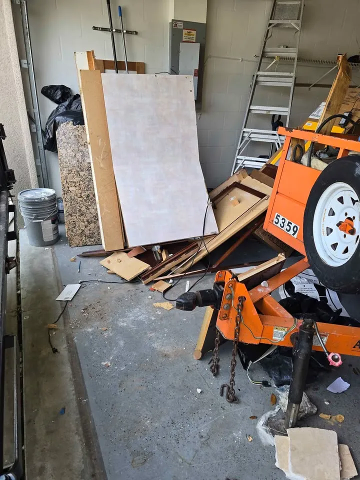 Garage cleared of debris with an orange dump trailer loaded at the door